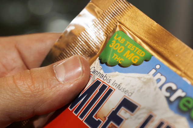 A caregiver points out the strength of an edible marijuana candy bar at a medical marijuana dispensary in Denver. In its entirety the candy bar is as strong at 30 marijuana joints.jpg